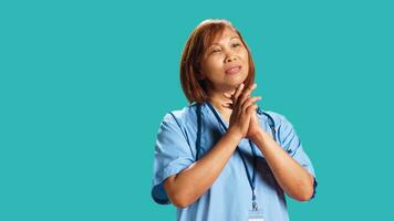 suplicando bipoc hospital empregado implorando gestão para salário elevação, fechar acima. Exausta enfermeira com mãos guardada dentro oração gesto implorando para dias desligado, isolado sobre estúdio fundo foto