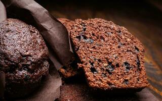 todo e dividido pela metade chocolate Bolinho em uma Sombrio fundo. bolinho com chocolate salgadinhos em Sombrio papel. foto