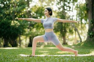 retrato do jovem mulher praticando ioga dentro jardim.fêmea felicidade. dentro a parque borrado fundo. foto