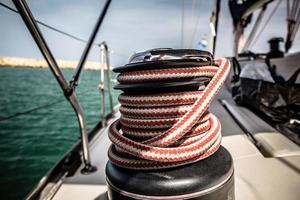 guincho com corda vermelha e branca em barco à vela no mar foto