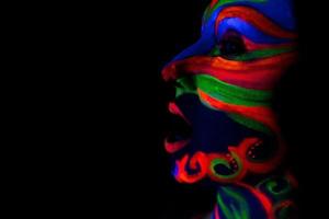 mulher com arte de maquiagem de pó uv fluorescente brilhante foto