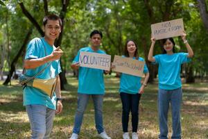 feliz jovem ásia alunos diverso voluntários aguarde uma campanha placa para limpeza dentro a parque, a conceito do de Meio Ambiente conservação em mundo meio Ambiente dia, reciclando, caridade para sustentabilidade. foto