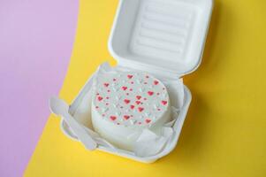 uma caixa com uma dia dos namorados dia bento bolo com corações carrinhos em uma Rosa e amarelo fundo foto