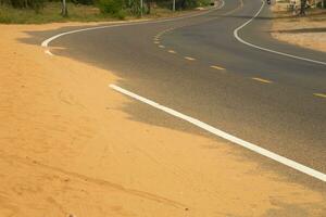 deserto areia passos em a asfalto estrada. foto