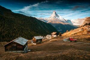 matterhorn montanha com caminhão dirigindo em a estrada e de madeira cabanas em a Colina dentro a manhã em outono às zermatt, Suíça foto