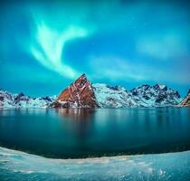 aurora boreal brilhando sobre neve montanha dentro hamnoy Vila às lofoten ilhas foto