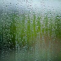 água gotas em a vidro molhado janela vidro com salpicos e gotas do água foto