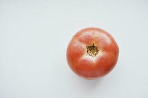 a fruta do uma tomate. uma vermelho tomate em uma branco fundo. foto