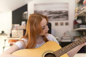 jovem tocando violão em casa foto