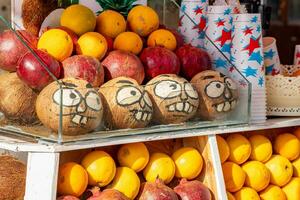 engraçado rostos pintado em cocos em a contador do uma fruta ficar de pé foto