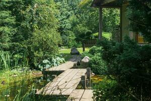 japonês jardim com uma ziguezague ponte sobre uma lagoa e uma chá casa foto