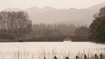 a bela paisagem de xihu com a velha ponte em arco e a torre do templo em Hangzhou, na China, no inverno foto