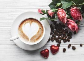uma xícara de café com padrão de coração em uma mesa