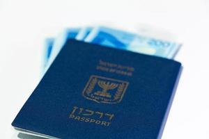 pilha de notas de dinheiro israelense de 200 shekel e passaporte israelense foto