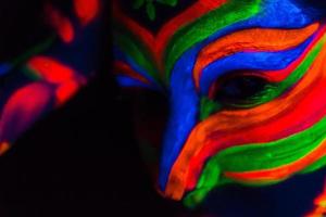 mulher com arte de maquiagem de pó uv fluorescente brilhante foto