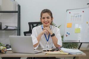 encantadora empresária asiática trabalhando com um laptop no escritório. olhando para a câmera. foto