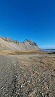 Stokksnes de praia características pitoresco Vestrahorn montanha alcance dentro tirar o fôlego congelando frio natural cenário. panorama do escandinavo litoral com íngreme arestas e islandês mares. foto