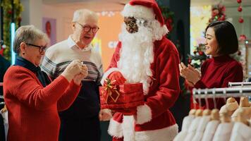 fechar acima tiro do homem vestido Como santa claus colheita sorteio bilhete dentro Natal decorado moda boutique durante festivo feriado temporada. por sorte Senior clientes ganhando roupas loja concurso foto