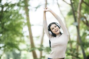 mulher asiática ouvindo música favorita em fones de ouvido. tempo feliz e relaxe. foto