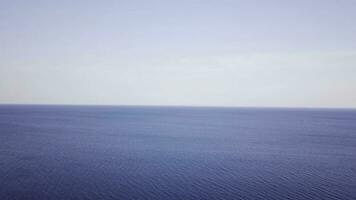 aéreo Visão calma mar e azul céu fundo. topo Visão do a mar superfície em uma ensolarado dia foto
