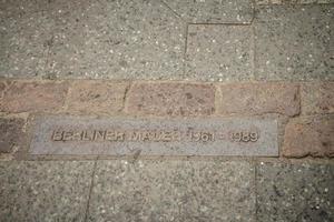 placa de parede de berlim na calçada que indica o local da parede de berlim até 1989 foto