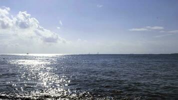 verão natural panorama com ondulado mar superfície brilhando brilhante em azul nublado céu fundo. conceito. Sol refletido dentro água superfície uma verão ensolarado dia. foto