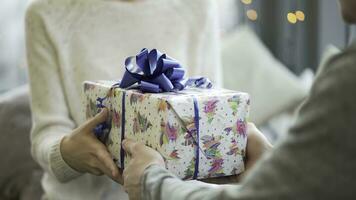 dia dos namorados dia conceito. uma amoroso casal a comemorar dia dos namorados dia dentro a restaurante. amantes dar cada de outros presentes. casal dando cada de outros Natal presentes. casal dando uma presente caixa para cada outro. foto