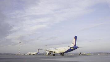 caudas do alguns aviões às aeroporto durante embarque operações. elas estão quatro aviões em uma ensolarado dia, com uma azul céu. viagem e transporte conceitos. foto