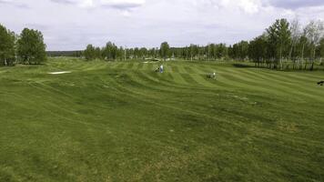 aéreo Visão golfe curso. golfistas caminhando baixa a fairway em uma curso com golfe saco e carrinho foto