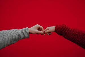ai gerado homem e mulher fechadas dedo juntos em vermelho cor fundo, feliz dia dos namorados dia conceito foto