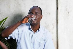 homem de meia-idade bebendo água em um copo foto