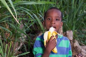 menino comendo uma fruta.