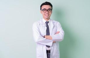 médico asiático em pé sobre fundo verde foto