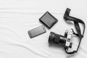 Móvel telefone, carteira, câmera em a cama feriado conceito preparando para ir foto