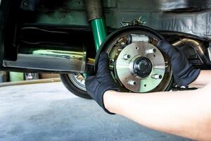 um homem muda a roda do rolamento do cubo automático do carro para o conceito de manutenção e ferramenta para serviço foto