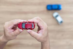 estragado brinquedo carro dentro a do homem mão e Novo carro em a chão acidente comparação do carro brinquedo foto