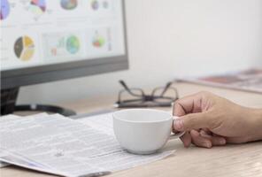 uma homem com uma café copo e lendo uma jornal olhando para uma trabalho conectados e Internet blog para Novo trabalhos foto