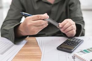 técnico aguarde apalpador calibre para Projeto trabalhos e usar lápis escrever em desenhando dentro Engenharia trabalhos com calculadora lápis e desenhando em mesa foto