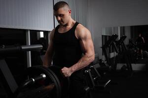 retrato do a atleta, uma Esportes homem treinador faz a exercício em simulador dentro a academia. saudável ativo estilo de vida, shakes músculos. conjuntos a kettlebell em a barra, ferro, ponderação foto