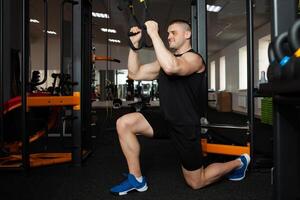 uma lindo treinador executa exercícios em simulador, agachamentos, flexões em peso, muscular corpo. atleta dentro a academia, treinamento, Individual peso perda cursos, Esportes, anúncio. sorridente foto