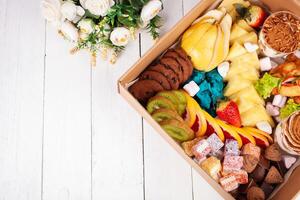 gastronômico caixa, comida, doces e frutas, flores para uma presente em marcha 8, fevereiro 14, aniversário. casa Entrega. esvaziar espaço foto