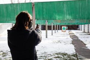 uma homem fotos uma alvo dentro uma traço. Esportes, entretenimento, armas de fogo, pistola.