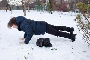 uma homem cai dentro a neve. a homem escorregou e estava ferido. queda em gelo. inverno. fratura, hematoma, luxação. foto