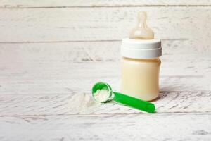 bebê garrafa com leite Fórmula em uma branco de madeira fundo foto