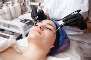 a esteticista executa a microcorrente procedimento dentro a beleza salão. foto