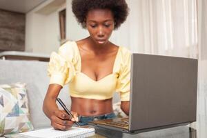 retrato do africano americano Preto mulher, trabalhador autonomo, trabalhando a partir de lar. computador portátil foto