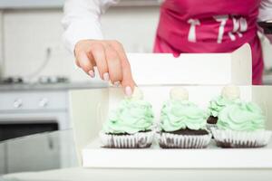 pasteleiro decora bolos de copo, caseiro culinária, doces. mãos foto