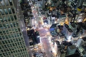 Visão do arranha-céu iluminar e tráfego em estrada dentro centro da cidade foto