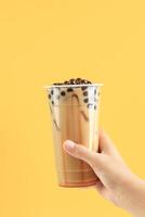 fêmea mão aguarde Taiwan boba pérola leite chá com líquido Palma açúcar xarope foto