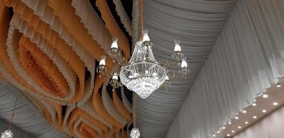 decorativo cristal lustre luminária em a teto dentro capina banquete corredor. foto